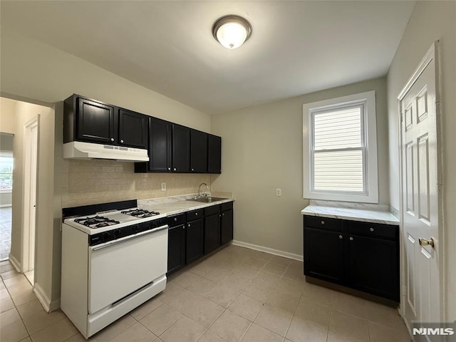 1 9th Ave, East Orange, NJ 07018 - kitchen featuring white range with gas cooktop, under cabinet range hood, dark cabinets, backsplash, and light countertops