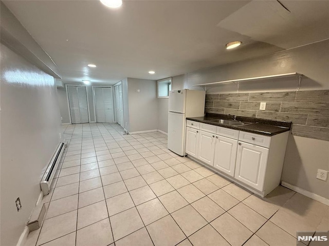1 9th Ave, East Orange, NJ 07018 - kitchen featuring freestanding refrigerator, decorative backsplash, baseboard heating, dark countertops, and light tile patterned floors