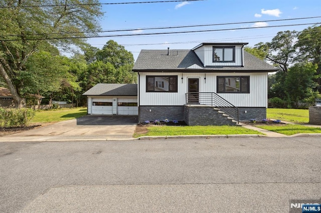 26 Lake, North Haledon, NJ 07508 - view of front of house featuring a detached garage, a front yard, an outbuilding, and a shingled roof
