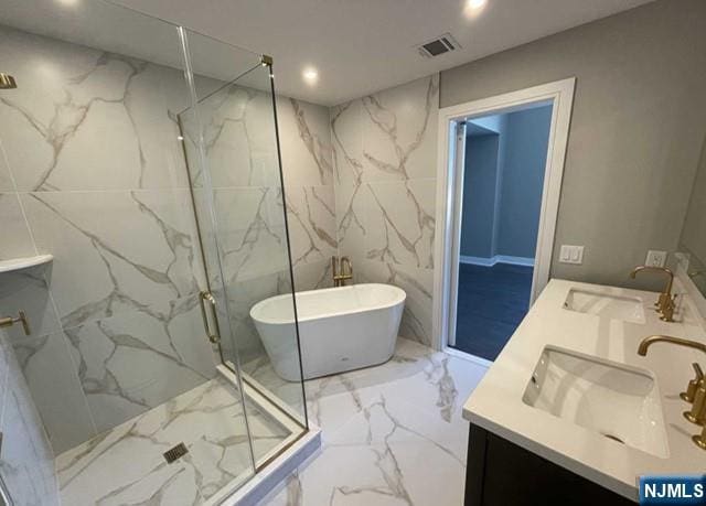 25 Division St Unit 403, Cresskill, NJ 07626 - bathroom with marble tiled flooring, a marble finish shower, a freestanding bath, double vanity, and tile walls