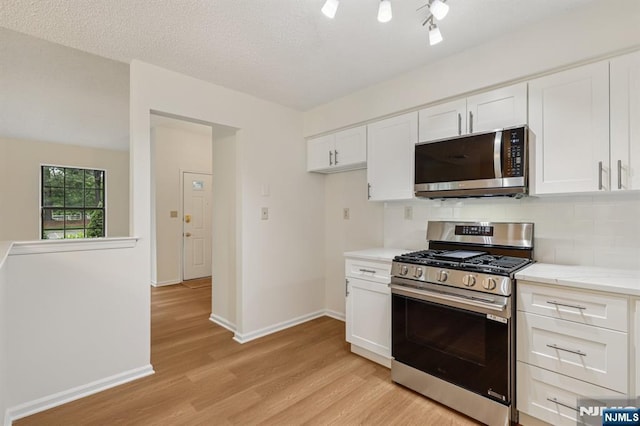 7 Eakens Ct, Mahwah, NJ 07430 - kitchen featuring stainless steel appliances, light wood-type flooring, white cabinetry, light stone countertops, and decorative backsplash
