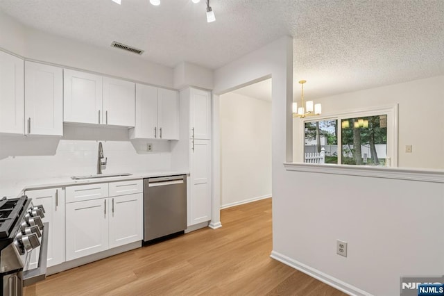 7 Eakens Ct, Mahwah, NJ 07430 - kitchen featuring stainless steel appliances, a chandelier, decorative backsplash, light wood-style flooring, and white cabinetry