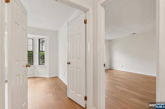 7 Eakens Ct, Mahwah, NJ 07430 - hallway with a textured ceiling and light wood-style flooring