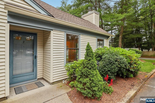 7 Eakens Ct, Mahwah, NJ 07430 - doorway to property featuring roof with shingles and a chimney