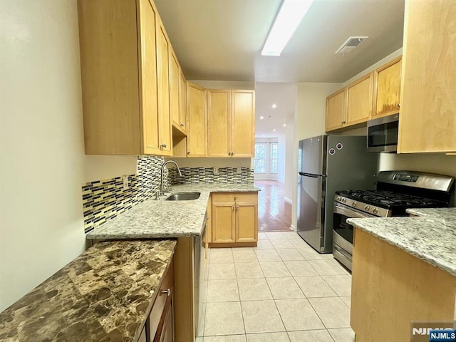 200 Dey St Unit 282, Harrison, NJ 07029 - kitchen featuring appliances with stainless steel finishes, light brown cabinetry, light stone counters, light tile patterned flooring, and decorative backsplash