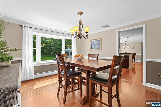 8 Fieldstone Dr, Kinnelon Borough, NJ 07405 - dining space with baseboard heating, a chandelier, crown molding, and light wood-style floors