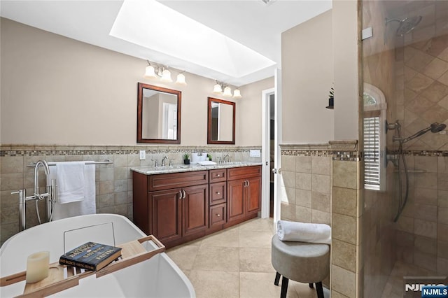 8 Fieldstone Dr, Kinnelon Borough, NJ 07405 - bathroom featuring tile walls, double vanity, a freestanding bath, tiled shower, and a skylight