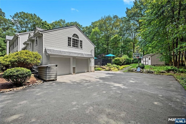 8 Fieldstone Dr, Kinnelon Borough, NJ 07405 - view of side of home with a shed, an attached garage, and asphalt driveway