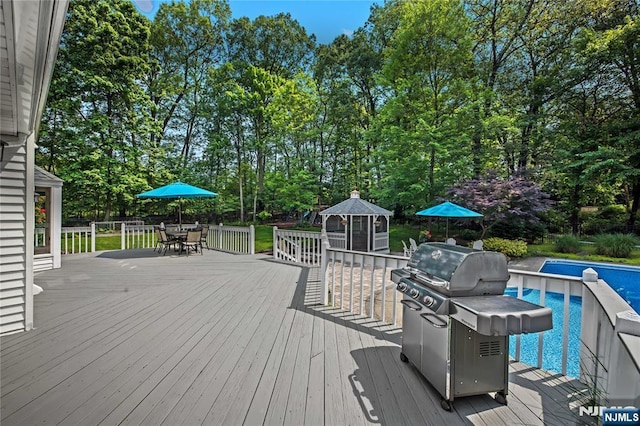 8 Fieldstone Dr, Kinnelon Borough, NJ 07405 - wooden deck with outdoor dining space, an outdoor pool, grilling area, and view of wooded area
