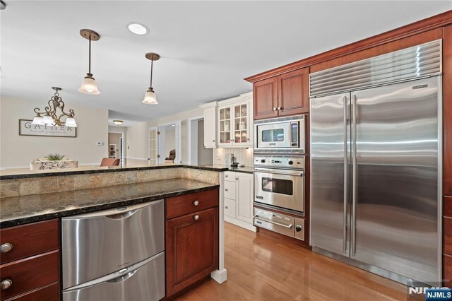 8 Fieldstone Dr, Kinnelon Borough, NJ 07405 - kitchen featuring built in appliances, a warming drawer, a chandelier, light wood-style floors, and hanging light fixtures