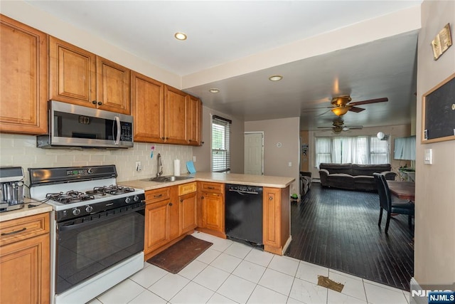 23 Preston St, Ridgefield Park, NJ 07660 - kitchen featuring stainless steel microwave, black dishwasher, range with gas cooktop, a peninsula, and light countertops