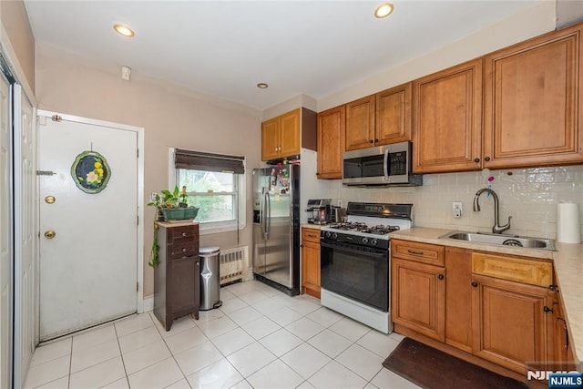 23 Preston St, Ridgefield Park, NJ 07660 - kitchen with appliances with stainless steel finishes, light countertops, brown cabinets, radiator, and backsplash