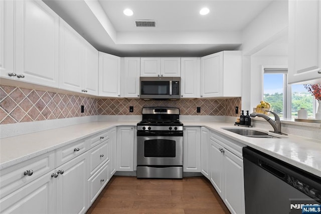 207 Jefferson Ct, Edgewater, NJ 07020 - kitchen featuring stainless steel appliances, dark wood finished floors, white cabinetry, decorative backsplash, and light countertops