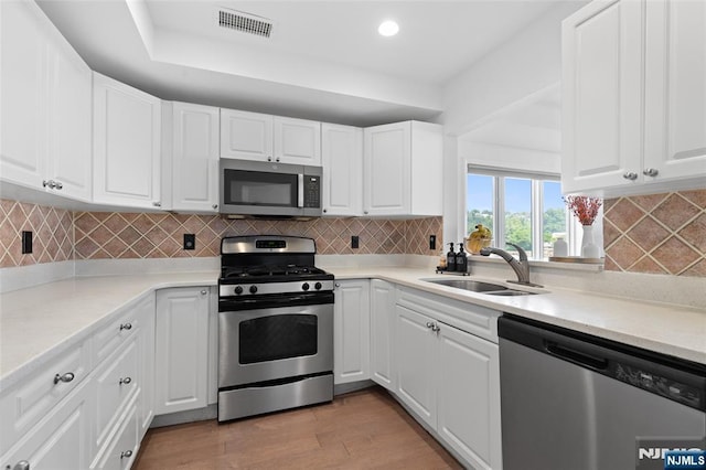 207 Jefferson Ct, Edgewater, NJ 07020 - kitchen featuring stainless steel appliances, white cabinets, light countertops, light wood finished floors, and recessed lighting