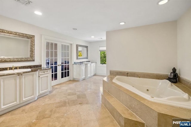 71 Roberts Rd, Englewood Cliffs, NJ 07632 - bathroom with french doors, vanity, a jetted tub, and recessed lighting