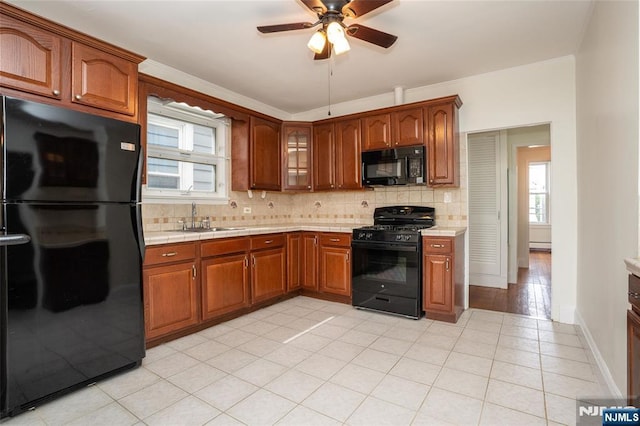 121 W 14th, Bayonne, NJ 07002 - kitchen featuring black appliances, a ceiling fan, decorative backsplash, glass insert cabinets, and light tile patterned flooring