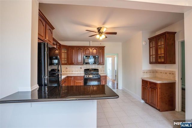 121 W 14th, Bayonne, NJ 07002 - kitchen featuring black appliances, a peninsula, decorative backsplash, and glass insert cabinets