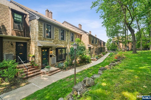 181 Long Hill Rd Unit H3, Little Falls, NJ 07424 - view of front facade with a front lawn, brick siding, and a chimney