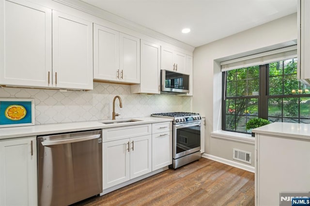 181 Long Hill Rd Unit H3, Little Falls, NJ 07424 - kitchen with appliances with stainless steel finishes, wood finished floors, light countertops, white cabinetry, and recessed lighting