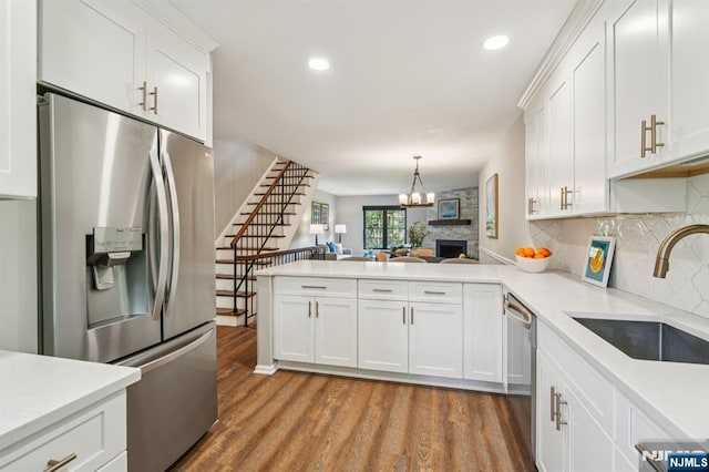 181 Long Hill Rd Unit H3, Little Falls, NJ 07424 - kitchen featuring stainless steel appliances, a peninsula, wood finished floors, light countertops, and open floor plan