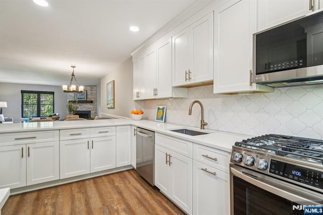 181 Long Hill Rd Unit H3, Little Falls, NJ 07424 - kitchen with stainless steel appliances, light countertops, white cabinets, wood finished floors, and backsplash