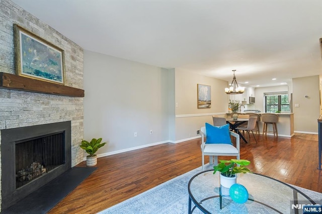 181 Long Hill Rd Unit H3, Little Falls, NJ 07424 - living area with wood finished floors, a fireplace, and a chandelier