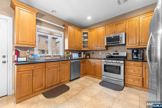 413 Washington Ave Unit C0413, Cliffside Park, NJ 07010 - kitchen featuring appliances with stainless steel finishes, tasteful backsplash, glass insert cabinets, brown cabinets, and recessed lighting