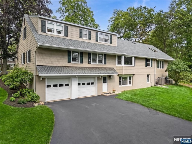 63 Kathleen Ct, Wayne, NJ 07470 - view of front of house with roof with shingles, asphalt driveway, a front lawn, a garage, and stucco siding