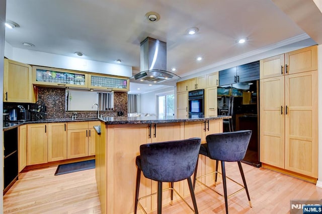 139 Donato Dr, Little Falls, NJ 07424 - kitchen featuring island range hood, black appliances, light brown cabinets, a breakfast bar area, and a kitchen island