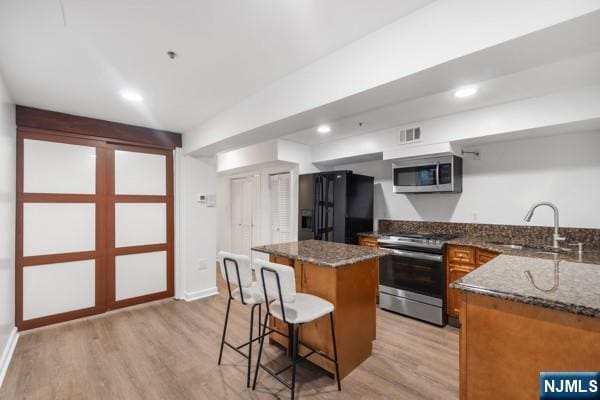 2608 Kennedy Blvd Unit 1, Union City, NJ 07087 - kitchen with appliances with stainless steel finishes, a center island, light wood-type flooring, a breakfast bar, and recessed lighting