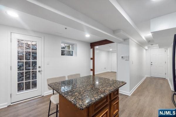 2608 Kennedy Blvd Unit 1, Union City, NJ 07087 - kitchen featuring light wood-type flooring, a kitchen bar, dark stone counters, a kitchen island, and recessed lighting
