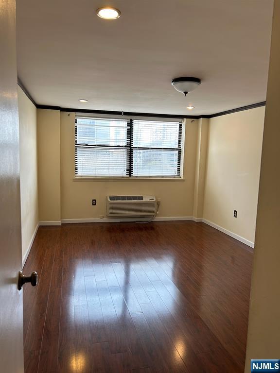 111 Mulberry St Unit 1418, Newark, NJ 07102 - empty room featuring a wall unit AC, wood-type flooring, and healthy amount of natural light
