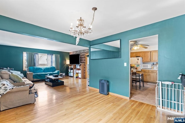 132 17th St, Prospect Park, NJ 07508 - living room with a chandelier, light wood-style flooring, and a ceiling fan