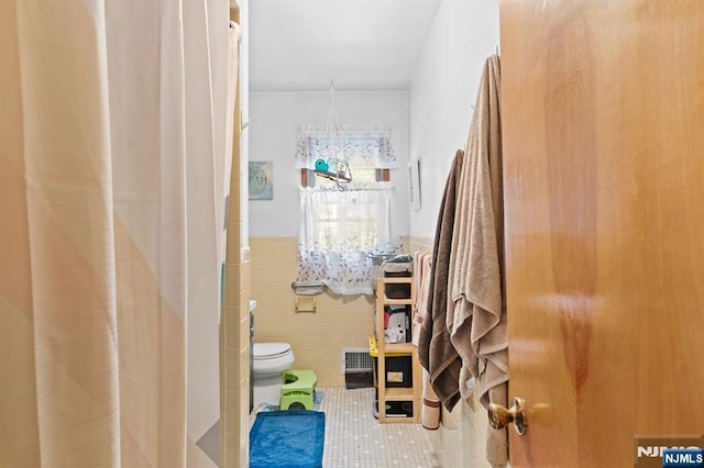 132 17th St, Prospect Park, NJ 07508 - bathroom with tile walls, tile patterned flooring, wainscoting, and a shower with shower curtain