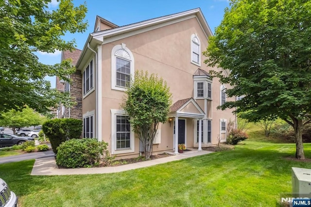 66 Spruce Ln, North Haledon, NJ 07508 - view of front of home with stucco siding and a front lawn