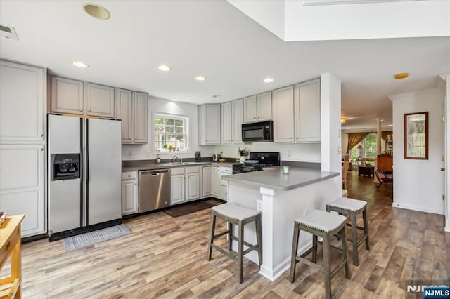 66 Spruce Ln, North Haledon, NJ 07508 - kitchen with fridge with ice dispenser, black microwave, stainless steel dishwasher, stove, and a breakfast bar
