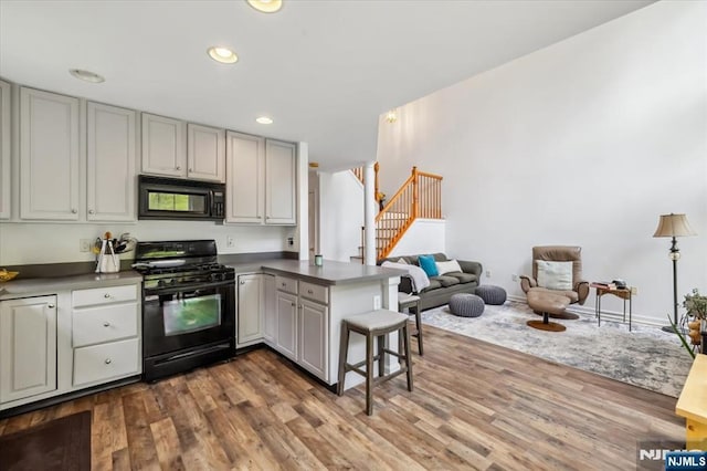 66 Spruce Ln, North Haledon, NJ 07508 - kitchen with black appliances, a peninsula, dark wood finished floors, open floor plan, and recessed lighting