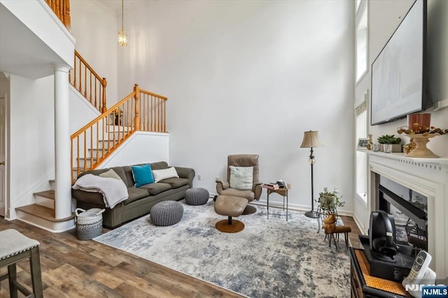 66 Spruce Ln, North Haledon, NJ 07508 - living area featuring wood finished floors, a high ceiling, stairs, and a glass covered fireplace