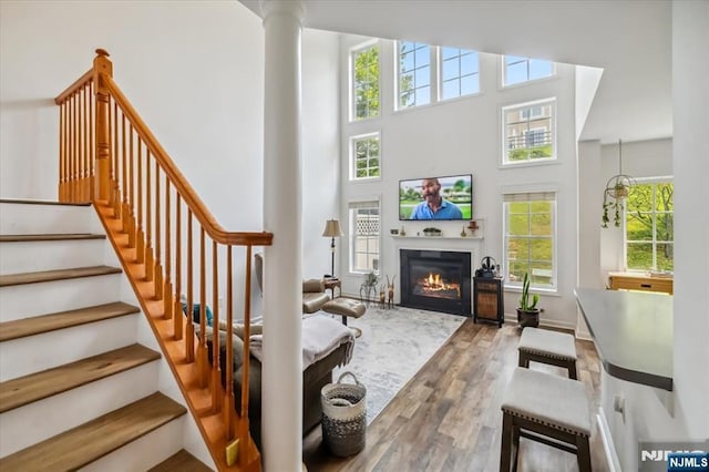 66 Spruce Ln, North Haledon, NJ 07508 - living area with wood finished floors, stairway, a high ceiling, and a glass covered fireplace
