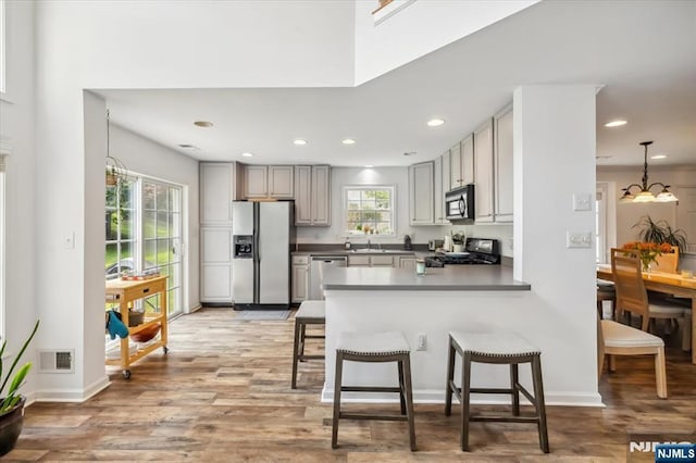 66 Spruce Ln, North Haledon, NJ 07508 - kitchen featuring fridge with ice dispenser, stove, black microwave, dishwasher, and a peninsula