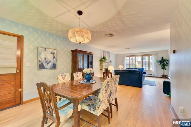 76 Central Ln, Secaucus, NJ 07094 - dining area with light wood finished floors, wallpapered walls, a chandelier, and a baseboard radiator