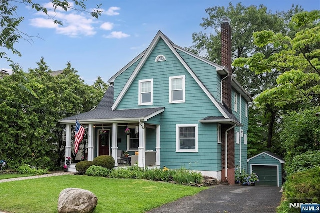 34 Harding Rd, Glen Rock, NJ 07452 - colonial inspired home with covered porch, an outdoor structure, asphalt driveway, a front lawn, and a garage