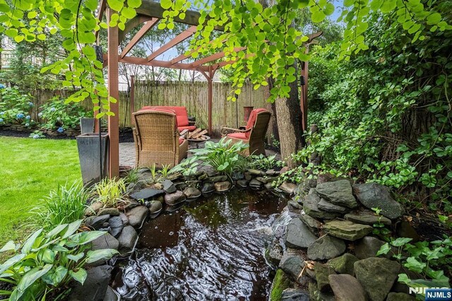 34 Harding Rd, Glen Rock, NJ 07452 - exterior view of a fenced backyard and a small pond