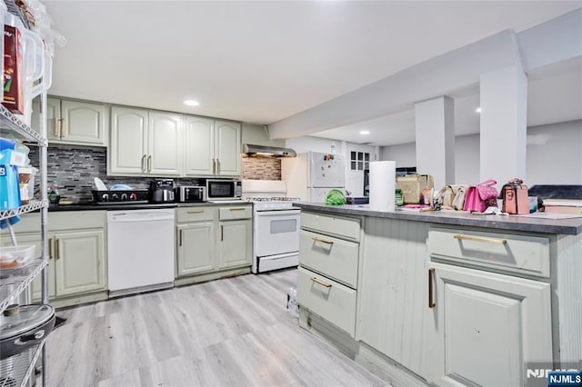 695 Midland Ave, Garfield, NJ 07026 - kitchen with white appliances, wall chimney range hood, backsplash, dark countertops, and recessed lighting