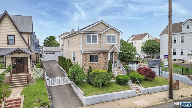 695 Midland Ave, Garfield, NJ 07026 - view of front facade with a gate, a garage, a residential view, and stone siding