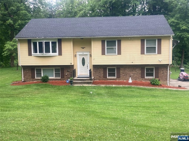 116 Scott Rd, Franklin, NJ 07416 - split foyer home with a front yard, brick siding, view of scattered trees, and a shingled roof