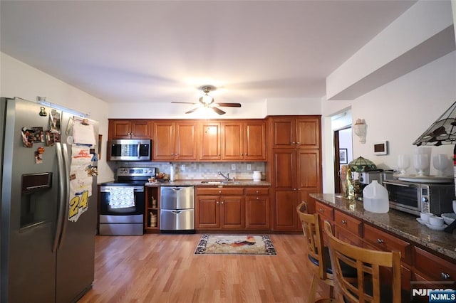 116 Scott Rd, Franklin, NJ 07416 - kitchen with stainless steel appliances, brown cabinetry, light wood finished floors, ceiling fan, and decorative backsplash