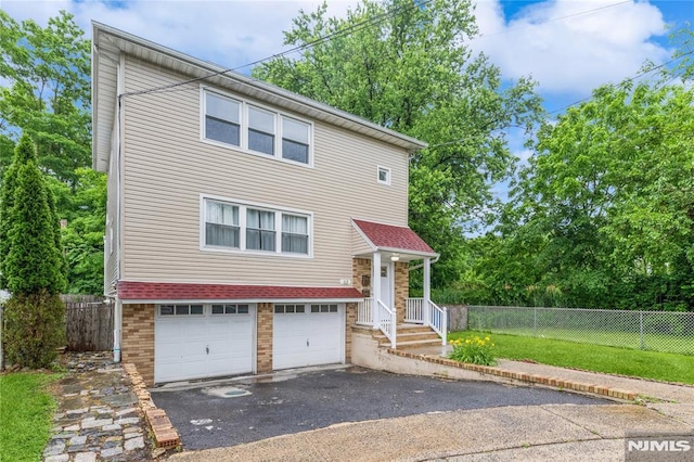 63 E Midland Ave, Kearny, NJ 07032 - view of front of house featuring driveway, an attached garage, and brick siding