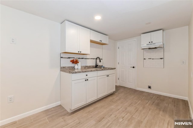 63 E Midland Ave, Kearny, NJ 07032 - kitchen featuring under cabinet range hood, light wood-type flooring, decorative backsplash, white cabinets, and recessed lighting