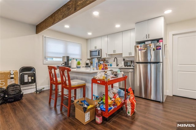 63 E Midland Ave, Kearny, NJ 07032 - kitchen featuring stainless steel appliances, dark wood-style flooring, white cabinetry, a breakfast bar area, and recessed lighting